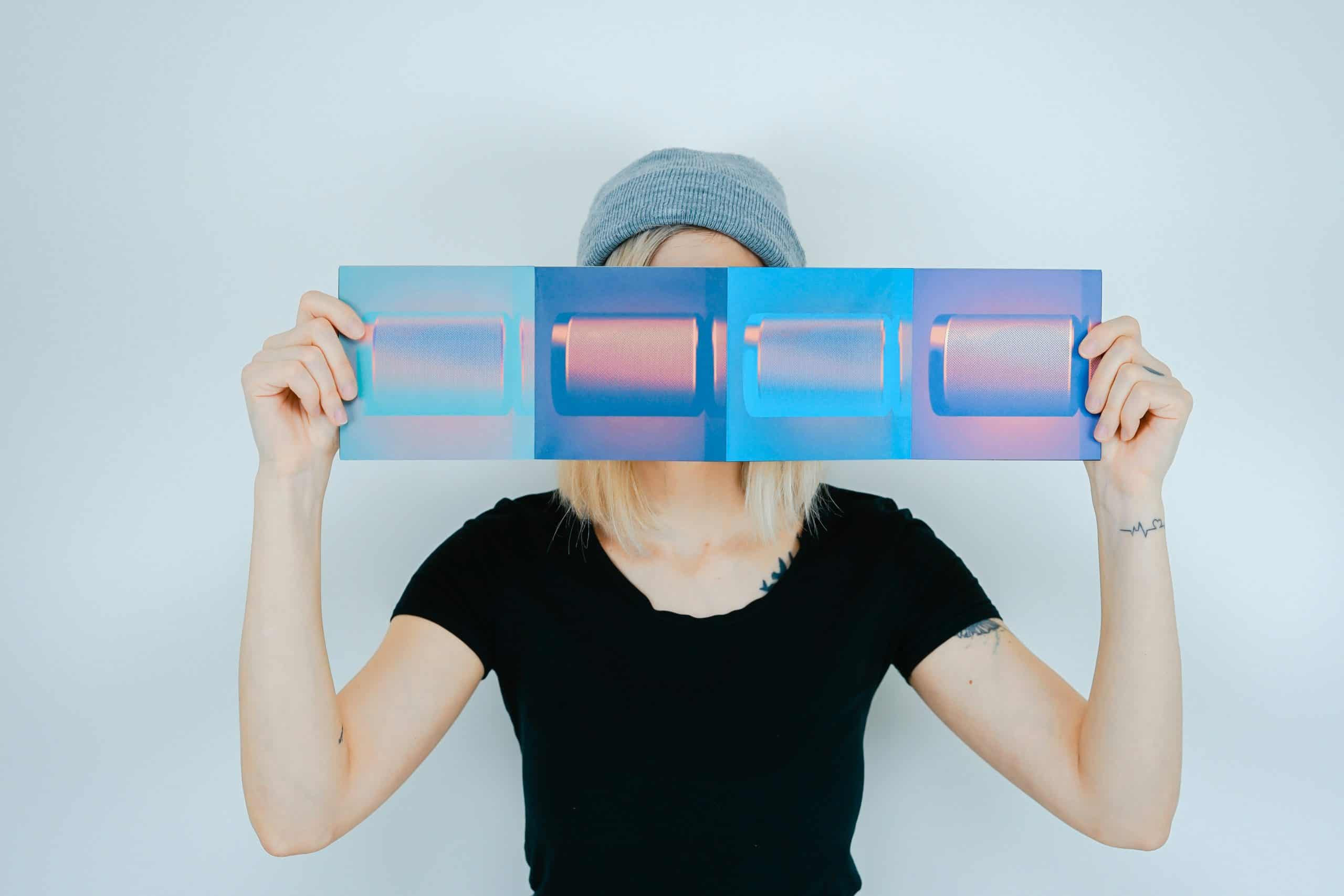 Creative woman holding holographic art print, modern digital design, vibrant colors, contemporary art, visual creativity, stylish photography for creative branding and marketing.