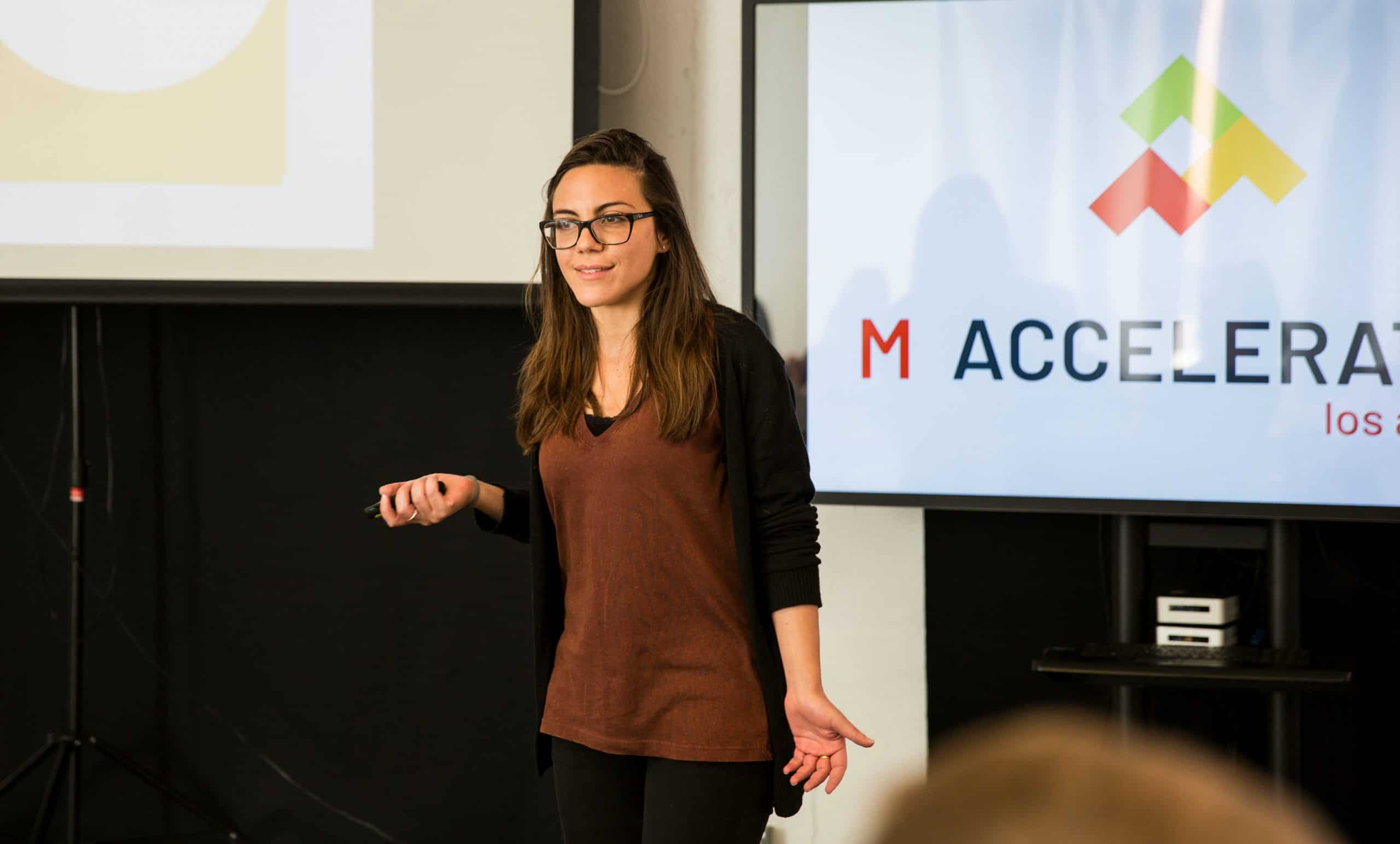 Innovative woman giving a presentation at a professional business conference, showcasing leadership, public speaking, and corporate training related to startups, entrepreneurship, and business growth.