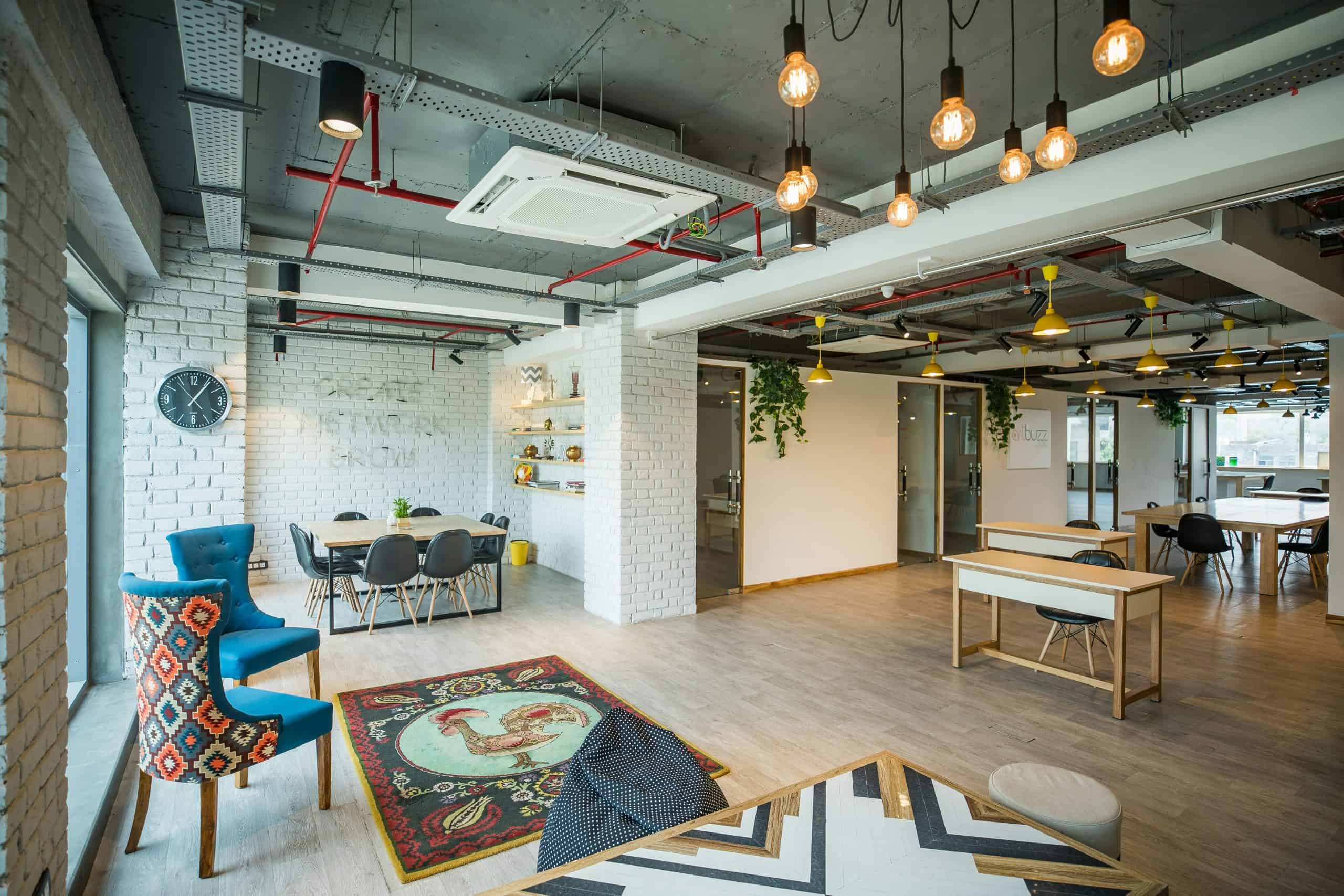 Modern coworking space with stylish furniture, hanging pendant lights, and open layout for productiv.