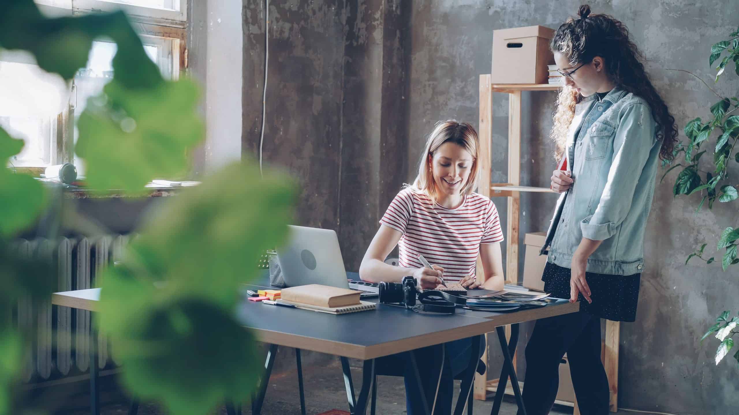 Two women collaborating in a modern office space at SOHO.
