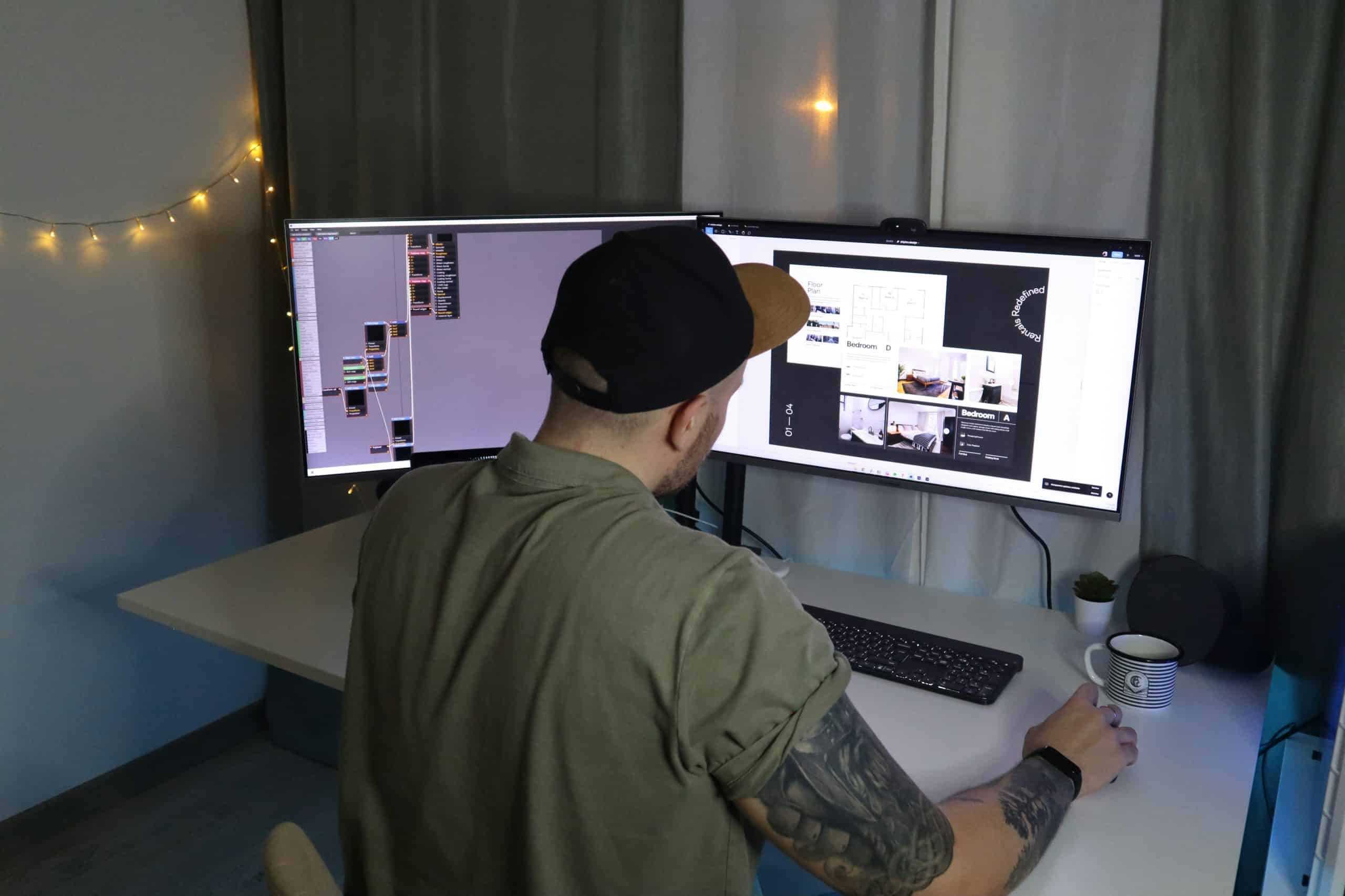 Person working on graphic design project with dual monitors in a modern workspace.
